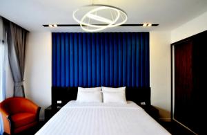 a bedroom with a bed with a blue curtain and a chandelier at Royal Dragon Boutique Hotel in Ho Chi Minh City