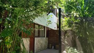 a brick house with a glass door in a forest at Complejo Casa Caracolnegro in Mar de Cobo
