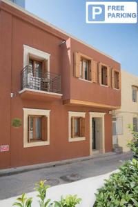 a large brown building with windows and a balcony at Candia Suites & Rooms in Heraklio Town