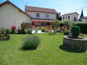 uma casa com um quintal com flores e plantas em Au Pied du Cognelot em Chalindrey