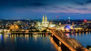 a view of a city at night with a bridge at XII Apostel Albergo in Cologne