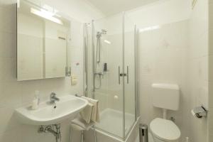 a bathroom with a shower and a sink and a toilet at Pension Wienerstub'n in Baden