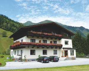 a building with two cars parked in front of it at Hotel Garni Wieshof in Rauris