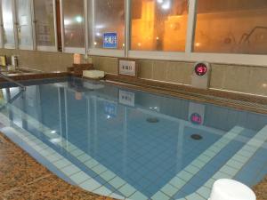 a large swimming pool in a building at Natural SPA, Kanazawa Hotel Yumenoyu in Kanazawa