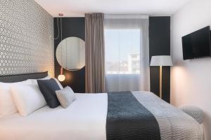 a hotel room with a bed and a window at Hôtel Innes by HappyCulture in Toulouse