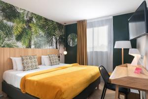 Habitación de hotel con cama, escritorio y sidra de mesa en Hôtel Innes by HappyCulture, en Toulouse