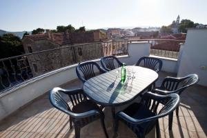 a table and four chairs on a balcony at Studio Apartmani Bijeli Delfin in Biograd na Moru