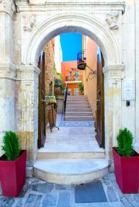 an archway in a building with two potted plants at Casa Moazzo Suites and Apartments in Rethymno