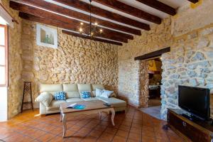 a living room with a couch and a tv at Town House Can Bassa in Muro