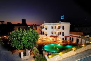 a view of a building with a swimming pool at night at Hotel Park Victoria in Ischia