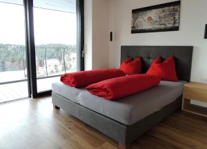a bedroom with a bed with red pillows on it at Residence Moritz in Avelengo