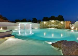 una grande piscina notturna con luci di La Pineta Hotel Beach & Spa ad Acciaroli