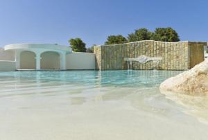 einen Wasserpool mit einem Zaun und einem Pool in der Unterkunft La Pineta Hotel Beach & Spa in Acciaroli