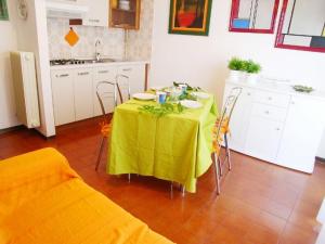 eine Küche mit einem Tisch und einem gelben Tischtuch in der Unterkunft Riviera Appartament in Grado