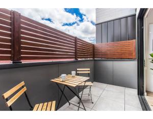 a patio with a table and chairs on a balcony at Boutique apartment in quiet, sought-after suburb in Carnegie