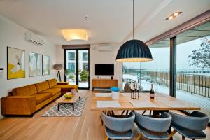 a living room with a couch and a table and chairs at Zatoka Komfortu BlueApart Jastarnia in Jastarnia