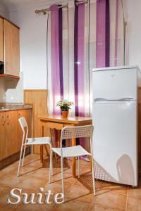 a kitchen with a table and a refrigerator and chairs at Irati in Benidorm