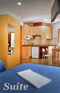 uma cozinha com armários de madeira e uma mesa com cadeiras em Irati em Benidorm