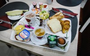 - un plateau de produits pour le petit-déjeuner et du café sur une table dans l'établissement Hôtel des Arcades, à Reims