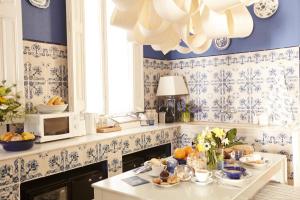 uma cozinha com papel de parede azul e branco e uma mesa com comida em Close to Passeig de Gracia em Barcelona