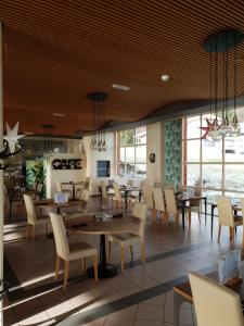 ein Restaurant mit Holzdecken, Tischen und Stühlen in der Unterkunft Hotel du Val in Malvilliers