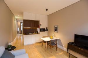 a living room with a table and a kitchen at Porto and Clérigos Views by Porto City Hosts in Porto