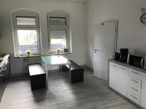 グラートベックにあるMonteur- und Ferienwohnungのキッチン(テーブル、冷蔵庫付)、窓が備わります。