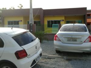 dois carros brancos estacionados em frente a um edifício em Residencial Alexandre em Matinhos