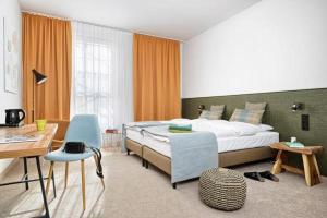 een slaapkamer met een bed, een tafel en een stoel bij Arche Hotel Lublin in Lublin