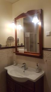 a bathroom with a sink and a mirror and lights at Apartma Lenka Kranjska Gora in Kranjska Gora +57 photos