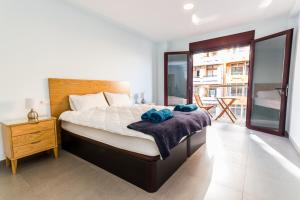 ラスパルマス・デ・グランカナリアにあるCanteras Luxury Beach Apartmentsのベッドルーム1室(木製ヘッドボード付きのベッド1台付)