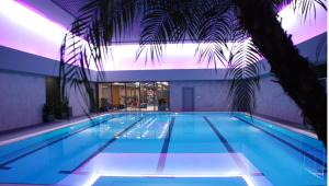 a swimming pool with a palm tree in a building at Point Hotel Barbaros in Istanbul