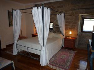 Un dormitorio con una cama con cortinas. en Casa das Pías, en Pías