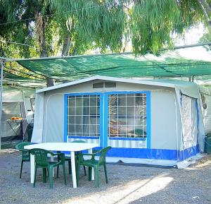 Tenda blu e bianca con tavolo e sedie di Villaggio Camping Maratea a Maratea
