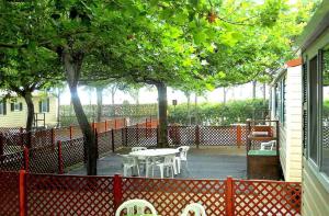 a patio with a table and chairs and trees at Villaggio Camping Maratea in Maratea