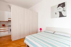 ボローニャにあるEmilia Levanteの白いベッドルーム(ベッド1台付)、キッチンが備わります。