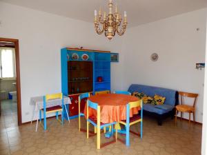 een eetkamer met een tafel en stoelen en een bank bij M156 - Marcelli, trilocale con giardino a 80mt dal mare in Marcelli
