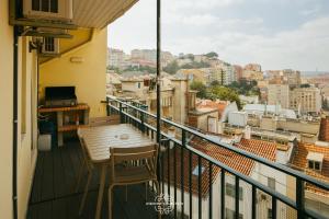 een balkon met een tafel en stoelen en uitzicht op de stad bij Top floor Amazing View Apartment 63 by Lisbonne Collection in Lissabon