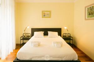 een slaapkamer met een groot wit bed met 2 lampen bij Top floor Amazing View Apartment 63 by Lisbonne Collection in Lissabon