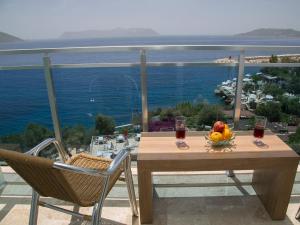 a table with a bowl of fruit and wine glasses at Rhapsody Hotel Kas in Kaş