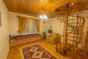 a living room with a bed and a spiral staircase at Beypazari Ipekyolu Konagi in Beypazarı