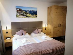 a bedroom with a bed with two towels on it at Hotel Aschauer Hof z'Fritzn in Kirchberg in Tirol