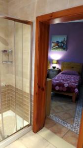 Habitación con una puerta de cristal que conduce a un dormitorio. en Il-Wileġ Bed & Breakfast, en Qala