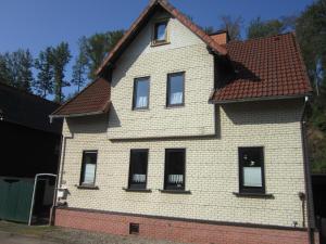 ein weißes Haus mit braunem Dach in der Unterkunft Dani´s Feriendomizil in Wieda