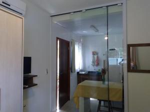 a living room with a table and a mirror at Encantada Floripa in Florianópolis