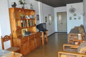 sala de estar con TV en un centro de entretenimiento de madera en Departamento en San Bernardo, partido de la costa en San Bernardo