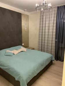 ニーコポリにあるАпартаменты1のベッドルーム1室(シャンデリア付きの大きな緑のベッド1台付)
