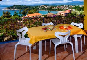 a dining table with a view of the ocean at Residence Appartamenti Caffarena in Àrbatax
