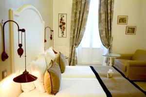 a bedroom with a bed and a couch and a window at Hotel Royal Bon Repos in Sainte-Maxime