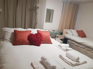 a bed room with a white bedspread and pillows at Forest In City Lodge in London